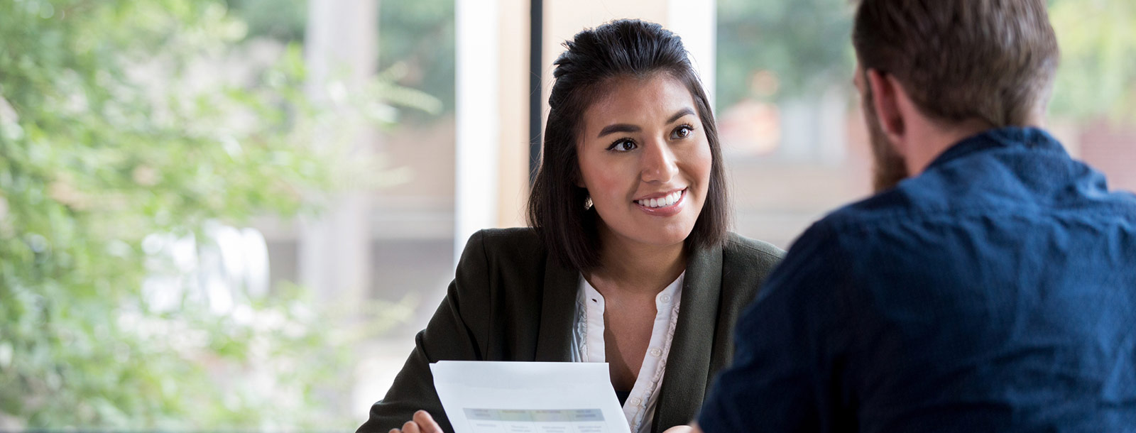Woman talking to man in office.