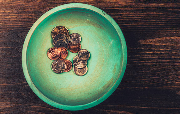 Coins in a dish on table.
