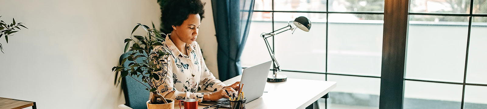 Woman using laptop in home office.